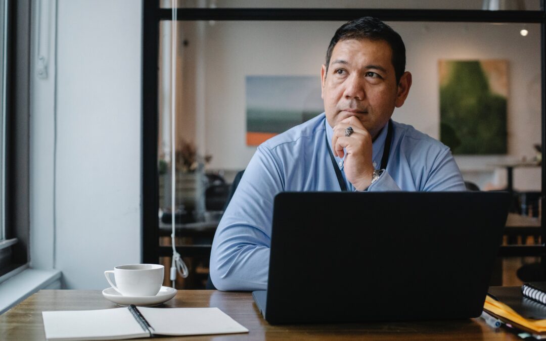small business owner reviewing payroll solutions on laptop